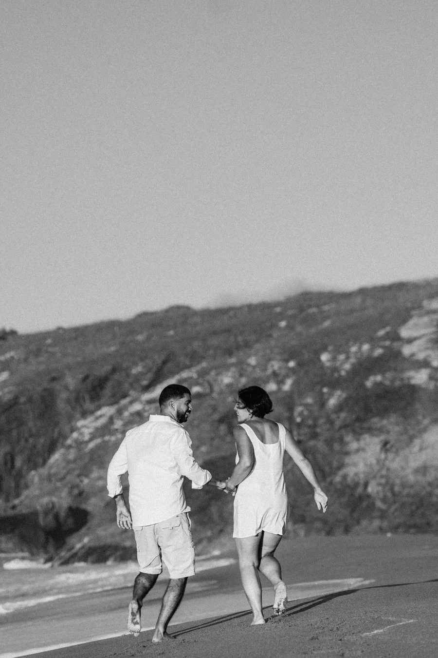 Pareja caminando por la playa, blanco y negro