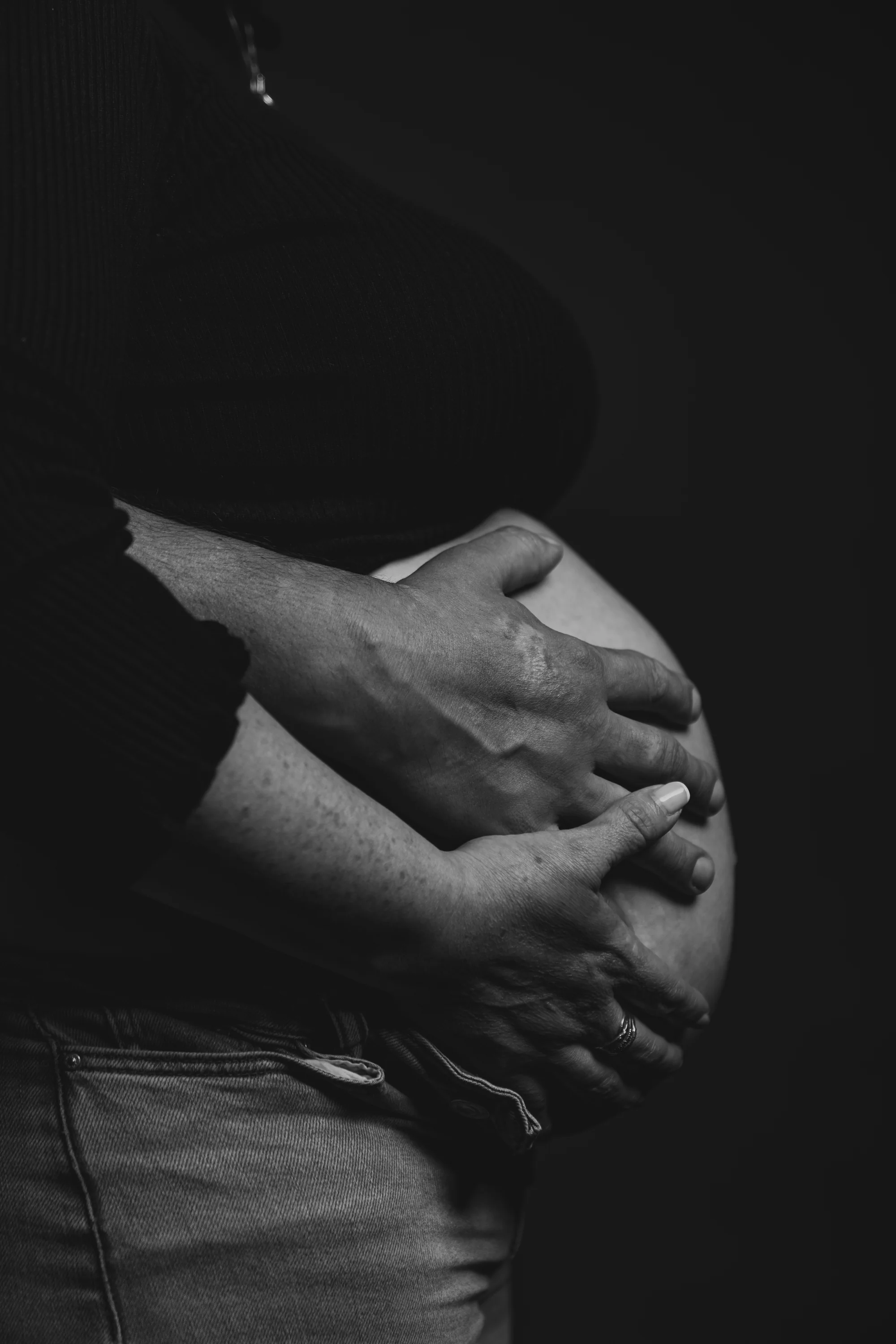 Manos sobre la panza, blanco y negro